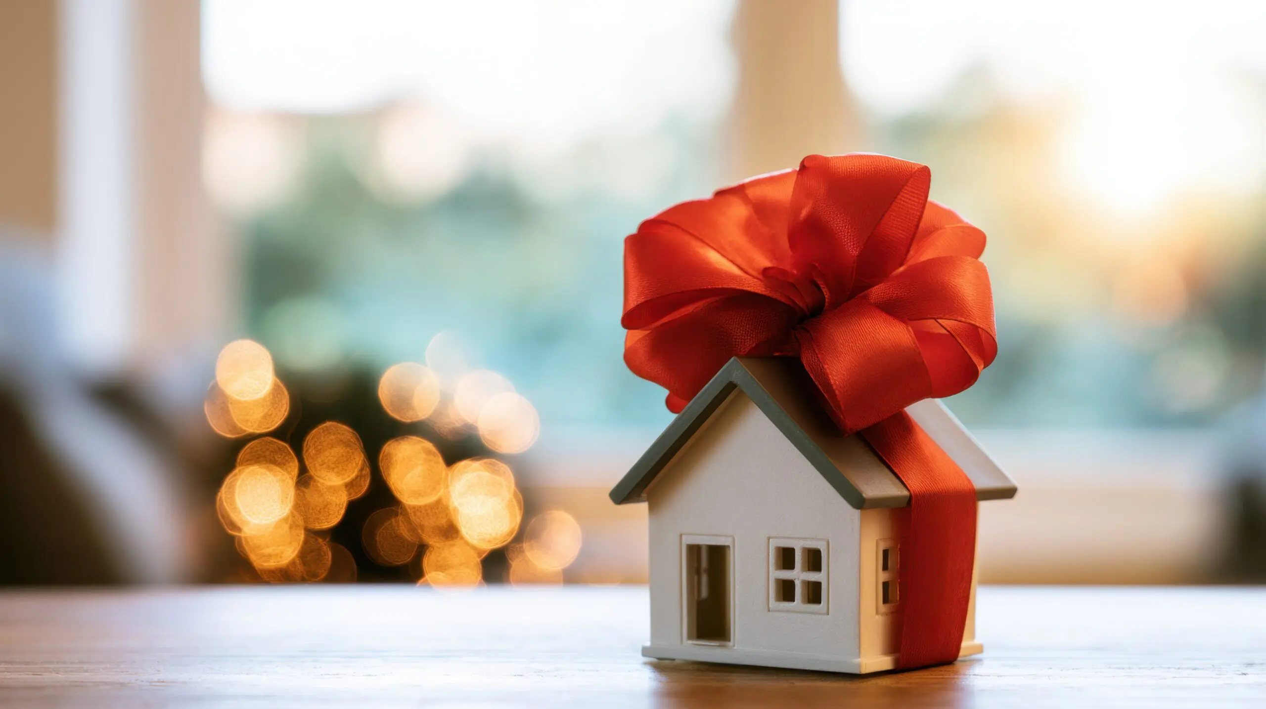Small house tied with a red ribbon, a gift of property to children
